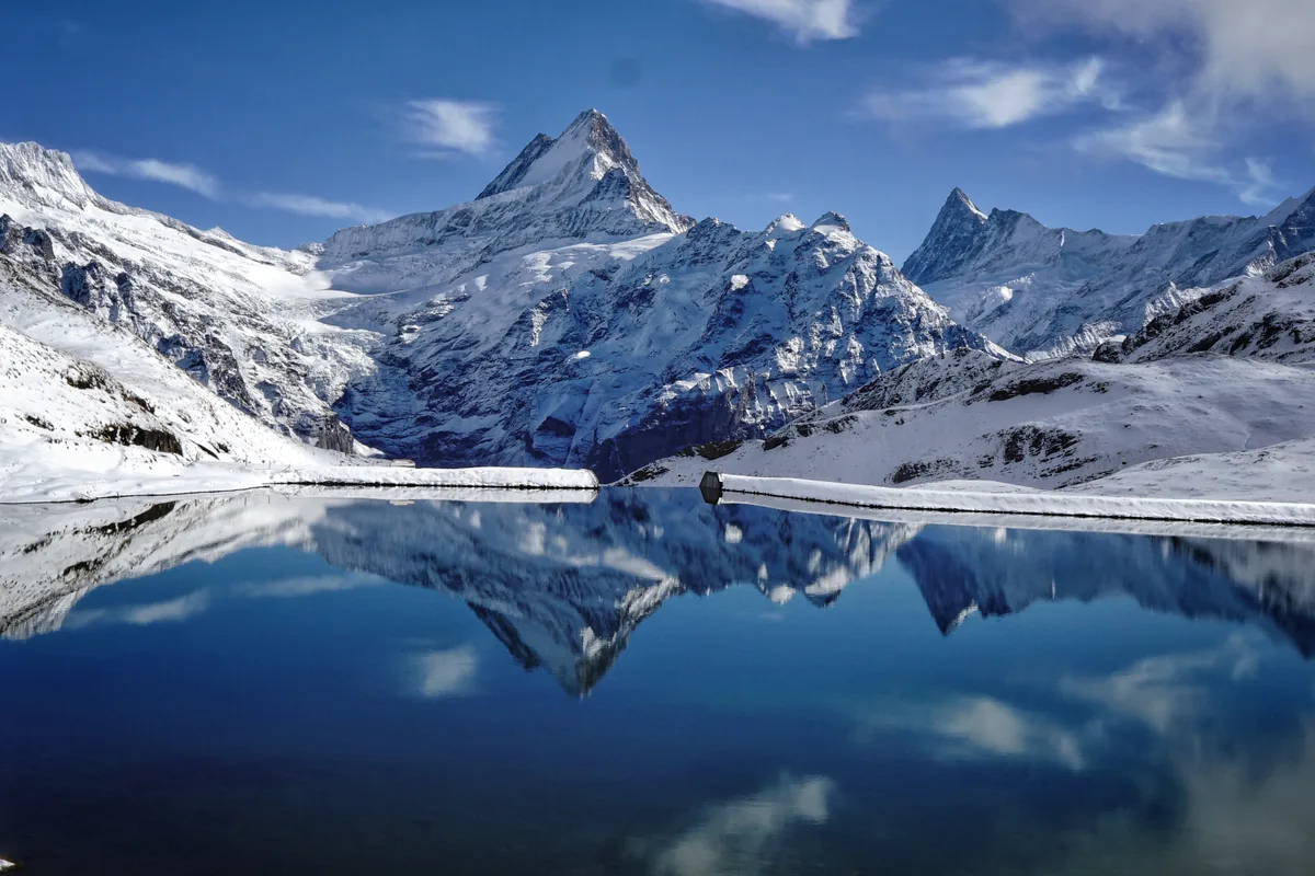 Der Bachalpsee unter Schnee, die umliegenden Gipfel und das Ufer schneebedeckt