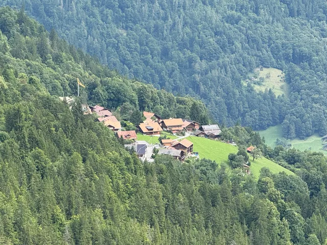 Der Weiler Isenfluh auf seiner grünen Terrasse, ringsum Wald und steile Hänge