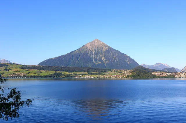 Die Pyramide des Niesen über dem stillen Thunersee, vom Ufer aus gesehen