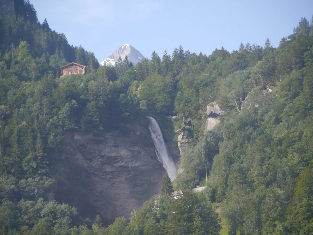 Der Reichenbachfall stürzt über die bewaldete Felsstufe, links oben das Stationsgebäude der Standseilbahn