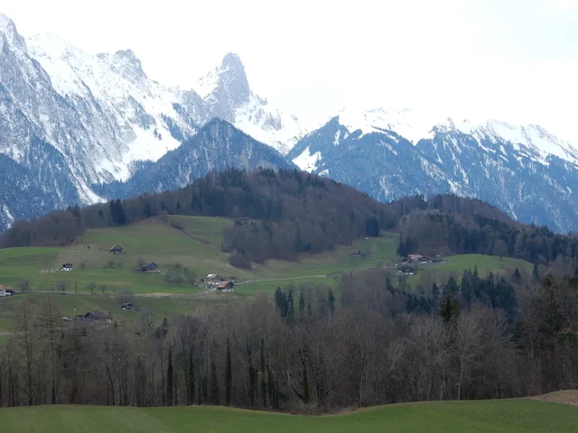 Die Felszacken des Stockhorns über Wiesen und einzelnen Höfen im Vorfrühling