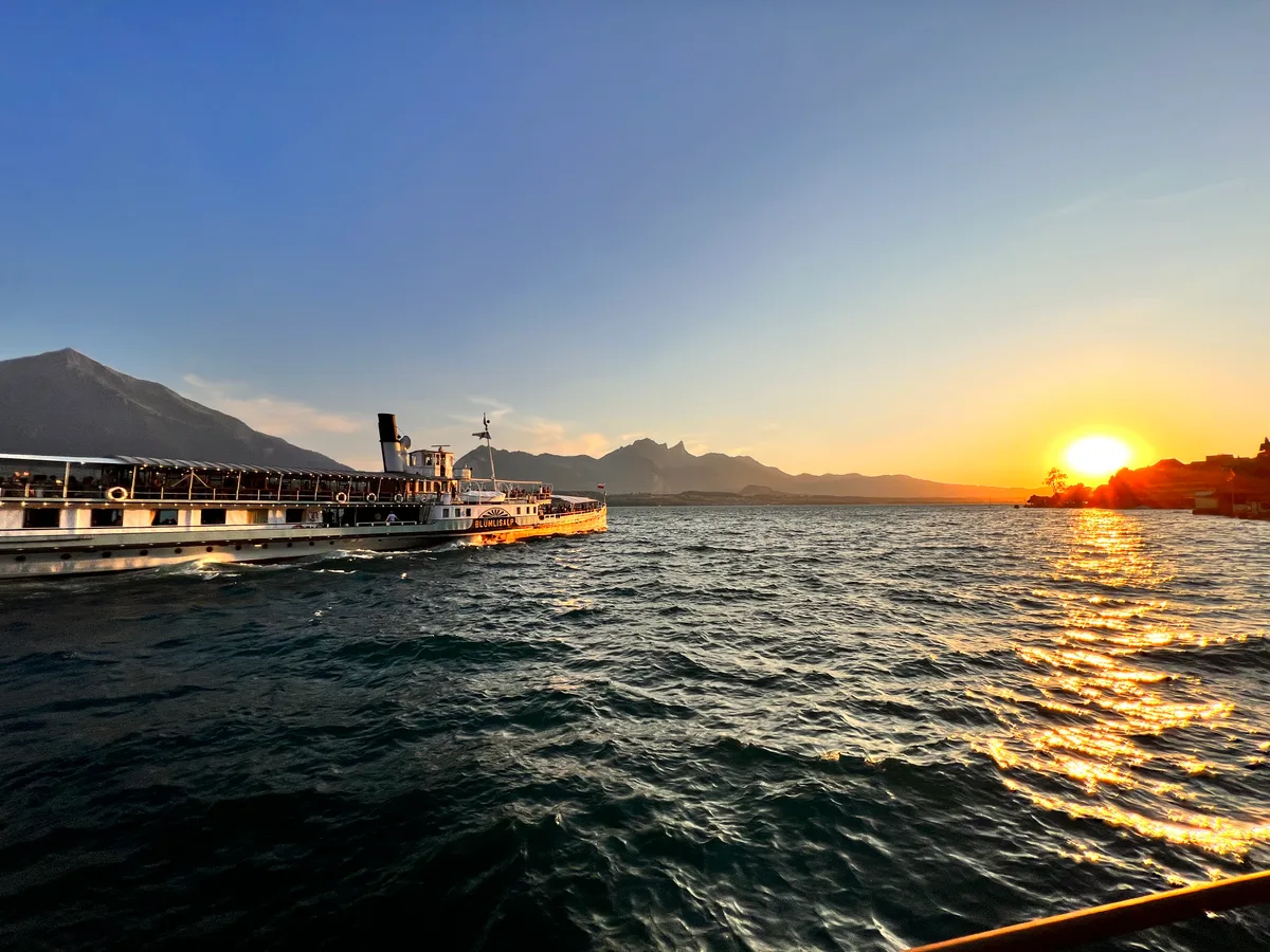 Der Dampfer Blümlisalp am Steg im Abendlicht, tief stehende Sonne über dem Thunersee